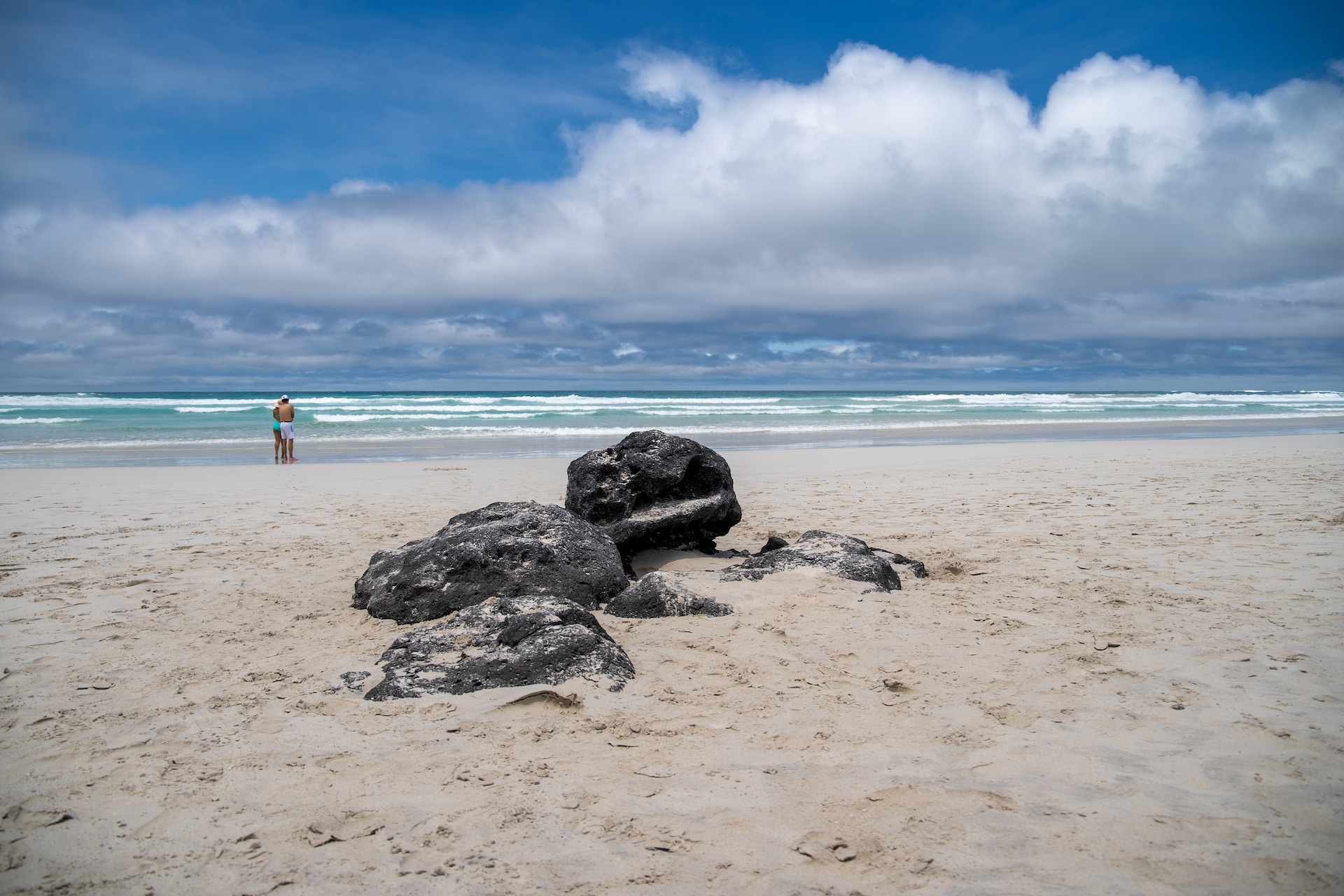 A person standing on a sandy beach. Photo: Rafael Idrovo Espinoza